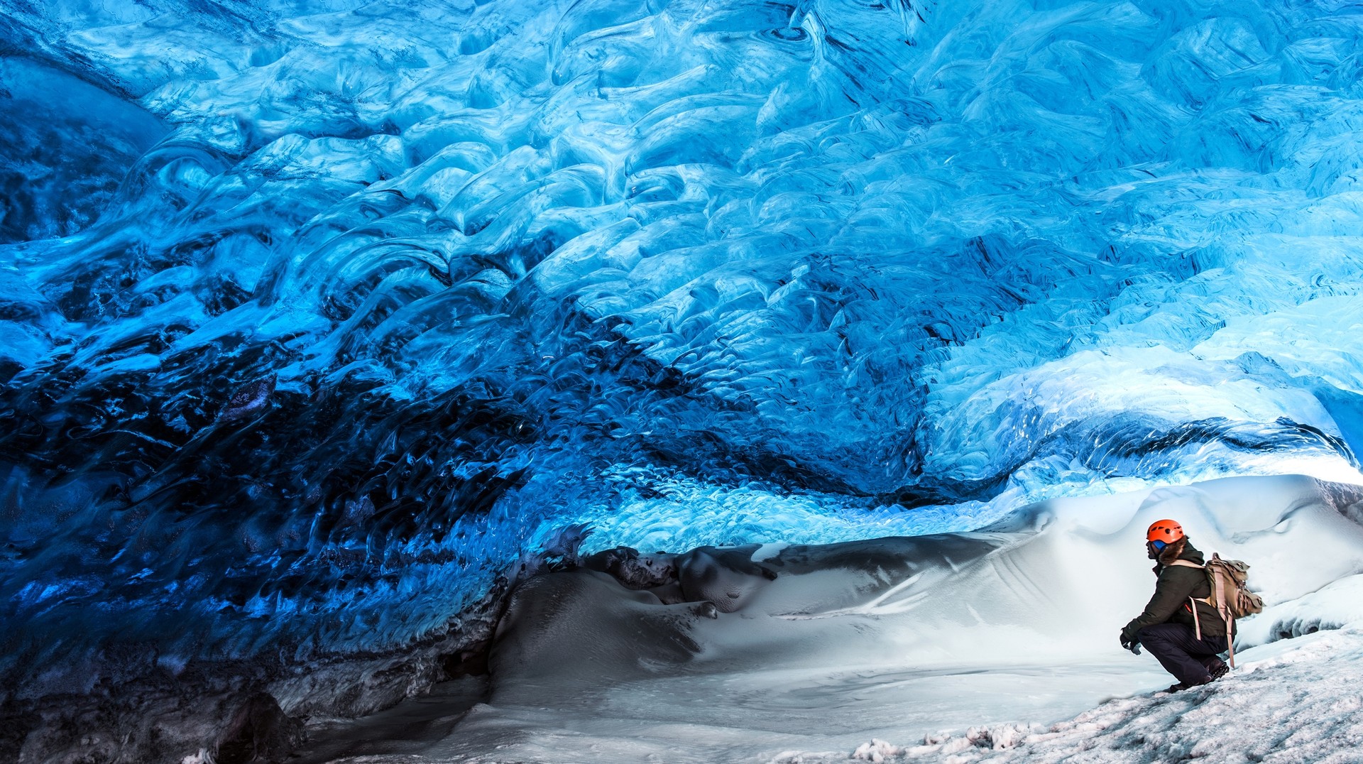 Traveler sitting in the Skaftafell glacier in Iceland Traveler sitting in the ice cave near Skaftafell glacier.