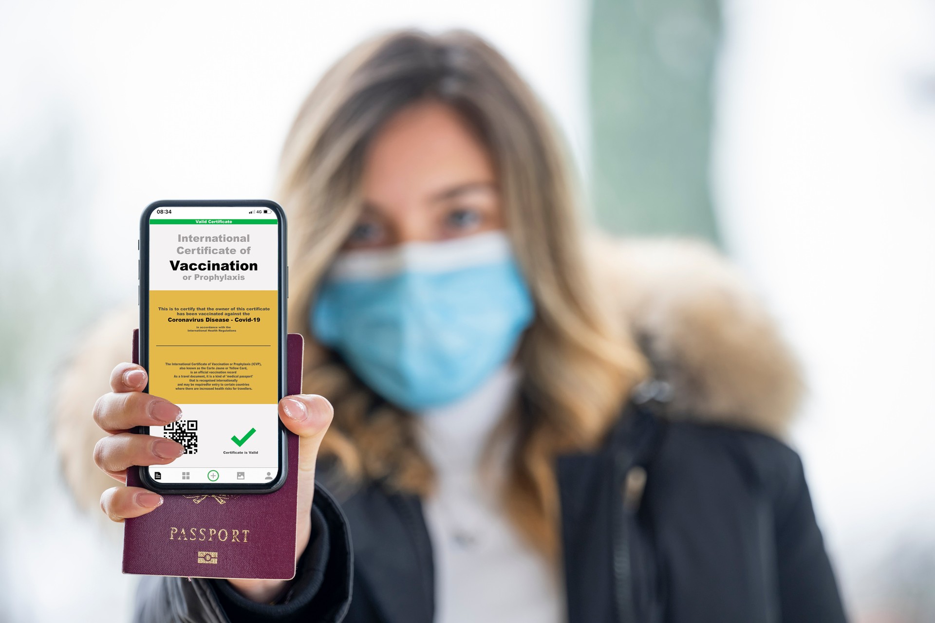 A person showing the status of vaccination on her mobile device.