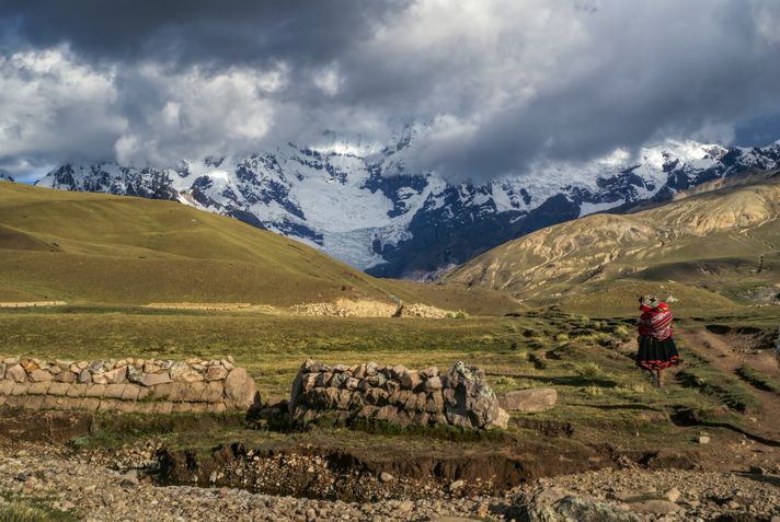 An indigenous woman walking on the Ausangate trekking trail