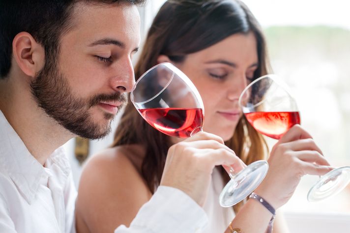 A man and a woman tasting red wine