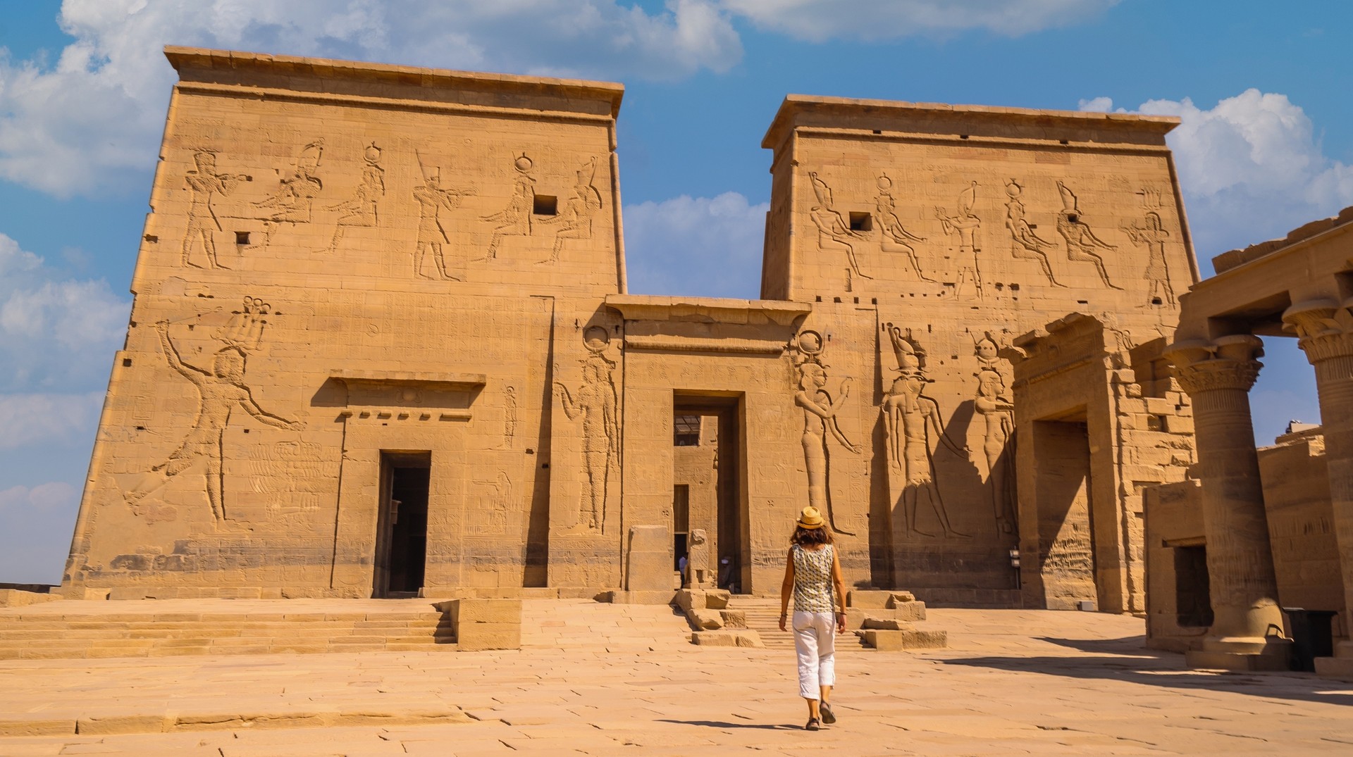 Dive into the magic of Egypt's temples, where each step is a hourney through time that tops the list of things to do in Egypt. A young tourist exploring the Temple of Philae in Aswan; one of the top things to do in Egypt.