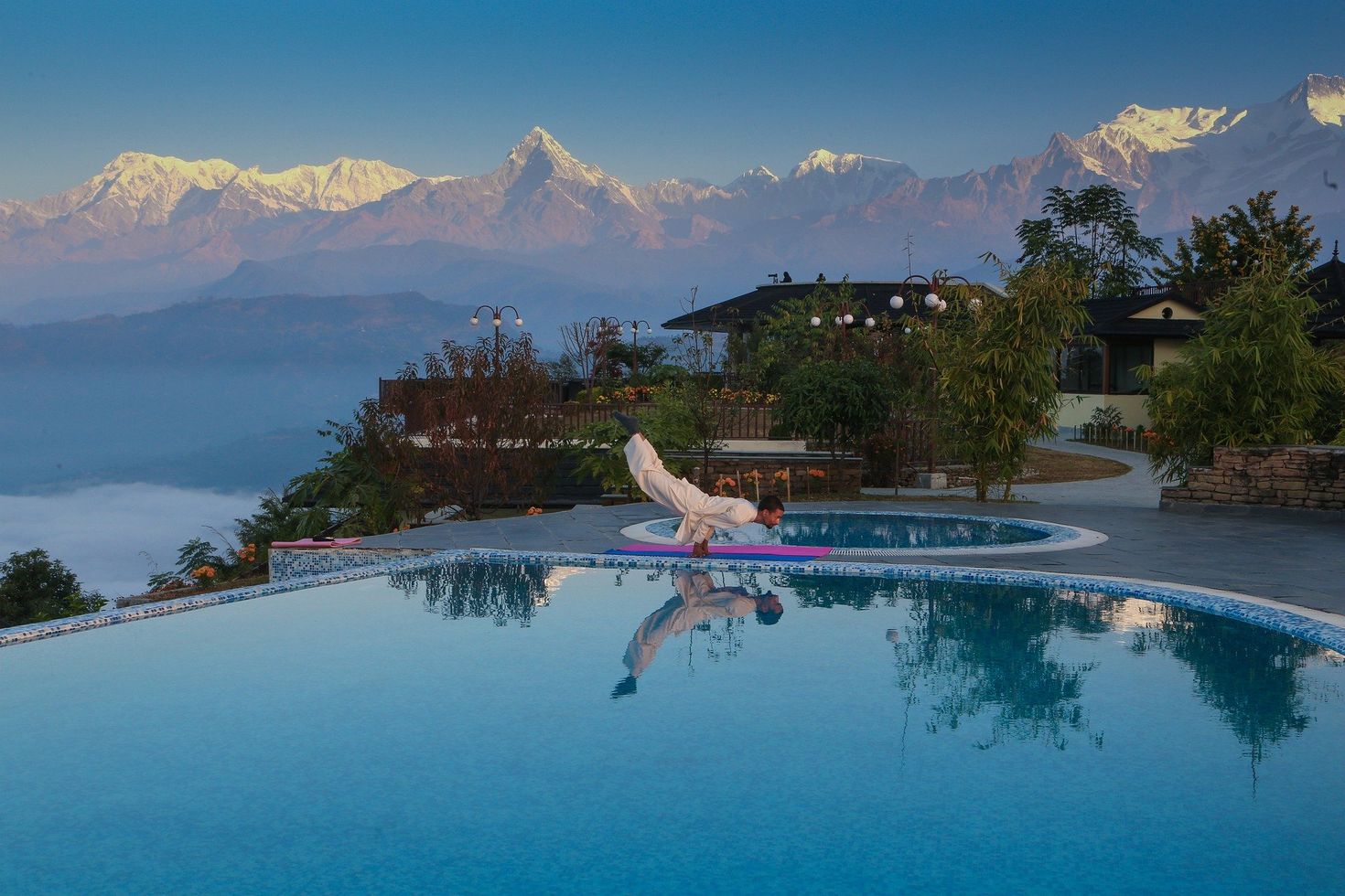 A man performing yoga with the mountains in the backdrop