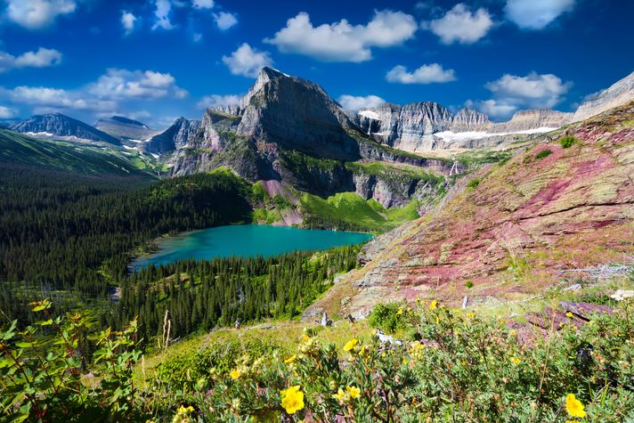 Rocky mountain with a blue lake at the bottom in Glacier National Park