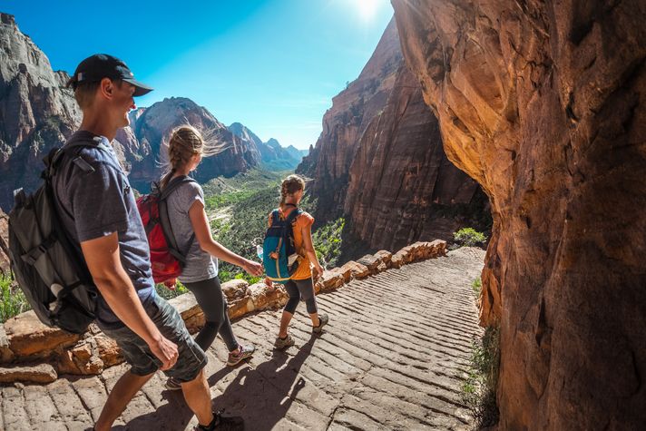 Three hikers on a trail in Zion National Park in USA