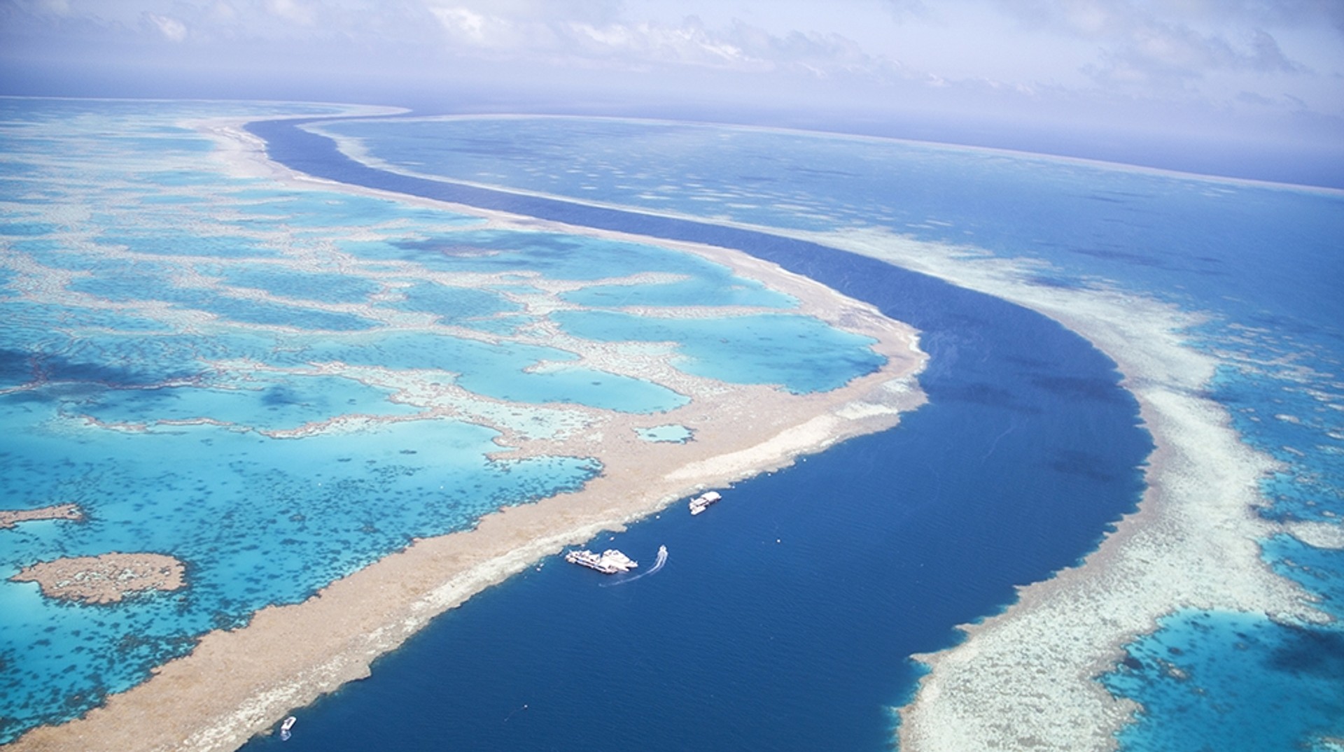 Great Barrier Reef is the largest collection of reefs in the world spanning 2500 km in the Northeast part of Australia. Aerial view of the tidal channel between the Great Barrier Reef