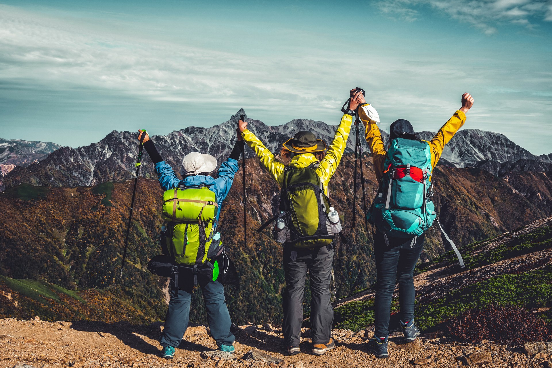 A hiker helps his friend climb up the hill during their travel.
