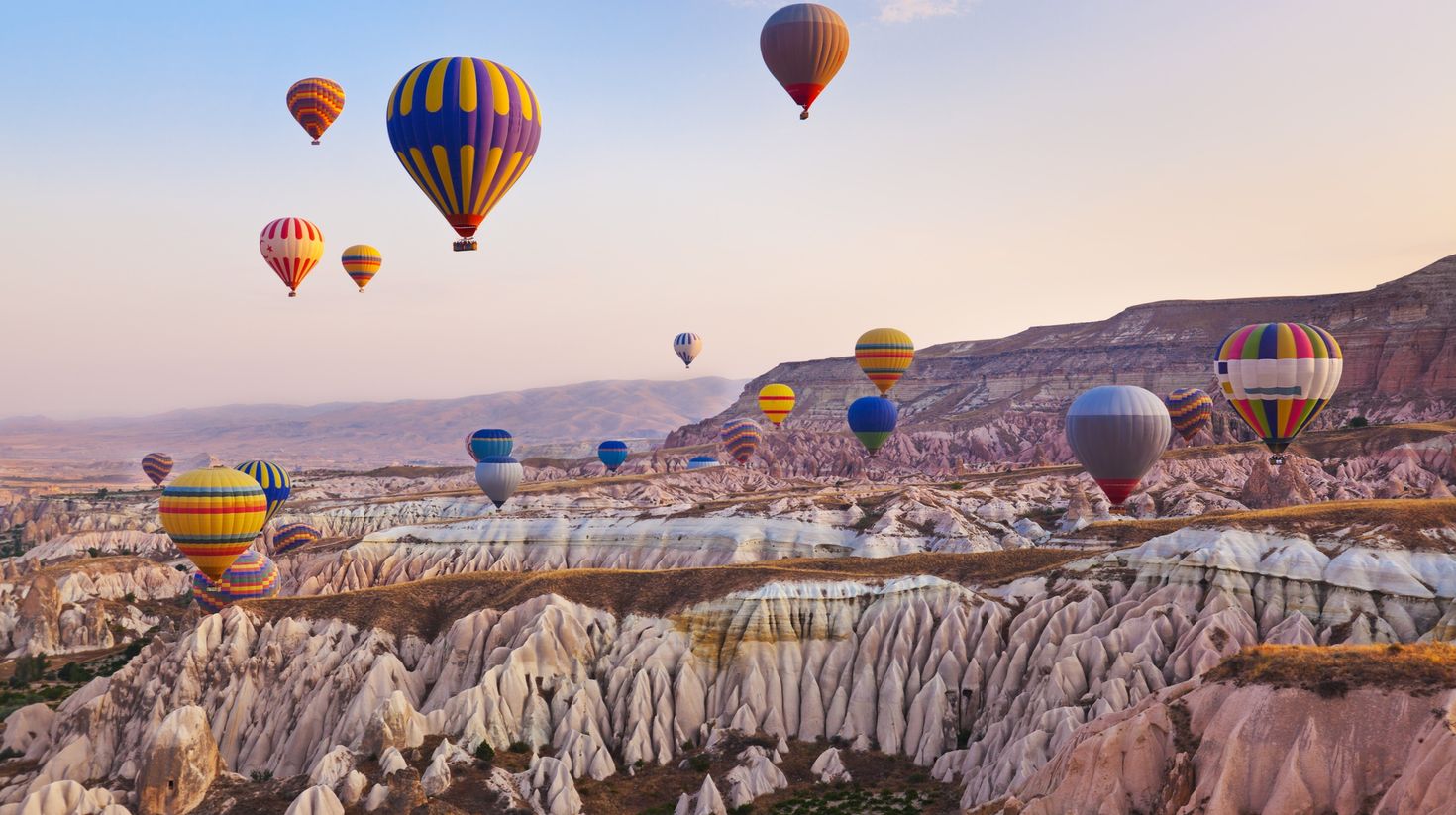 See hot air balloons rise during sunset in Cappadocia during a 10-day trip in Turkey.