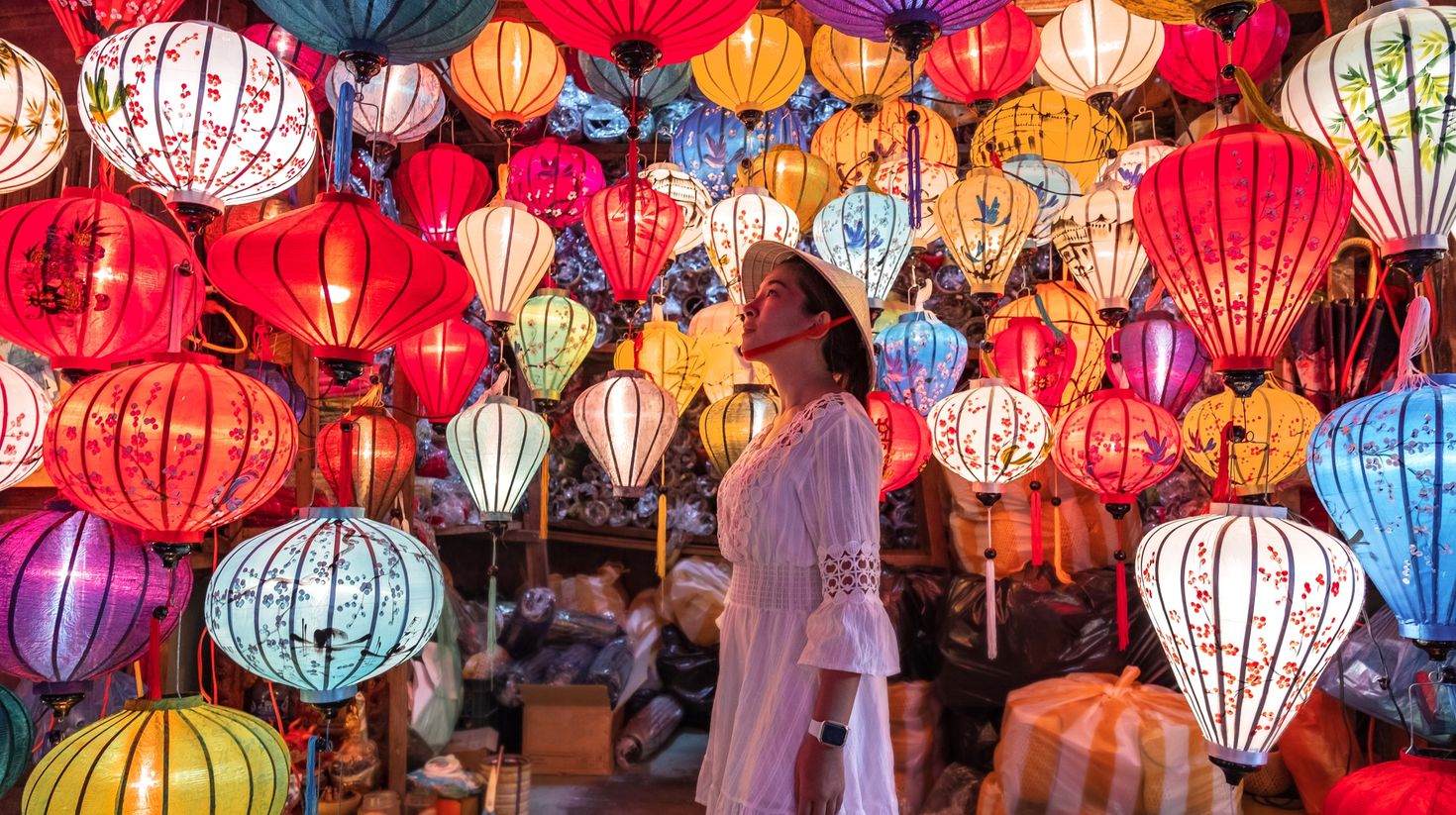 A woman choosing between multiple lanterns in Hoi An.