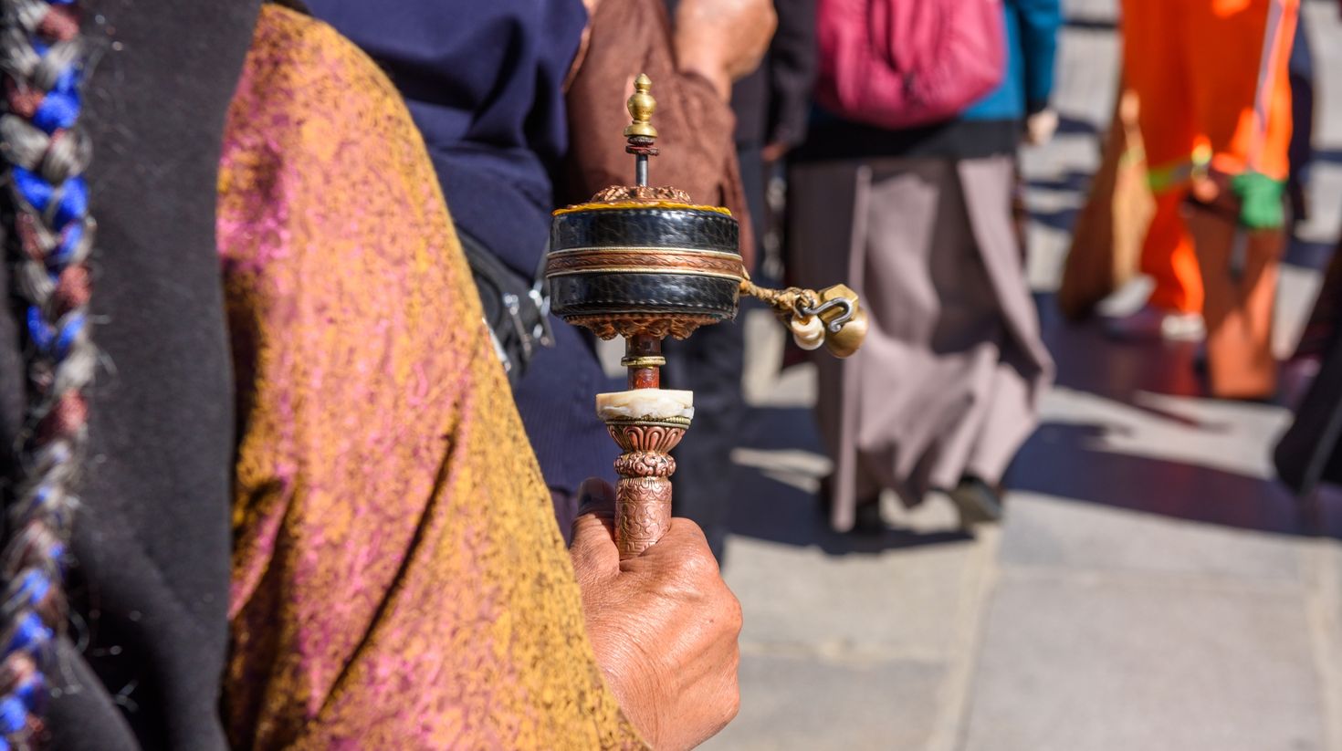 An old Tibetan lady swinging the prayer wheel on Tibet visit