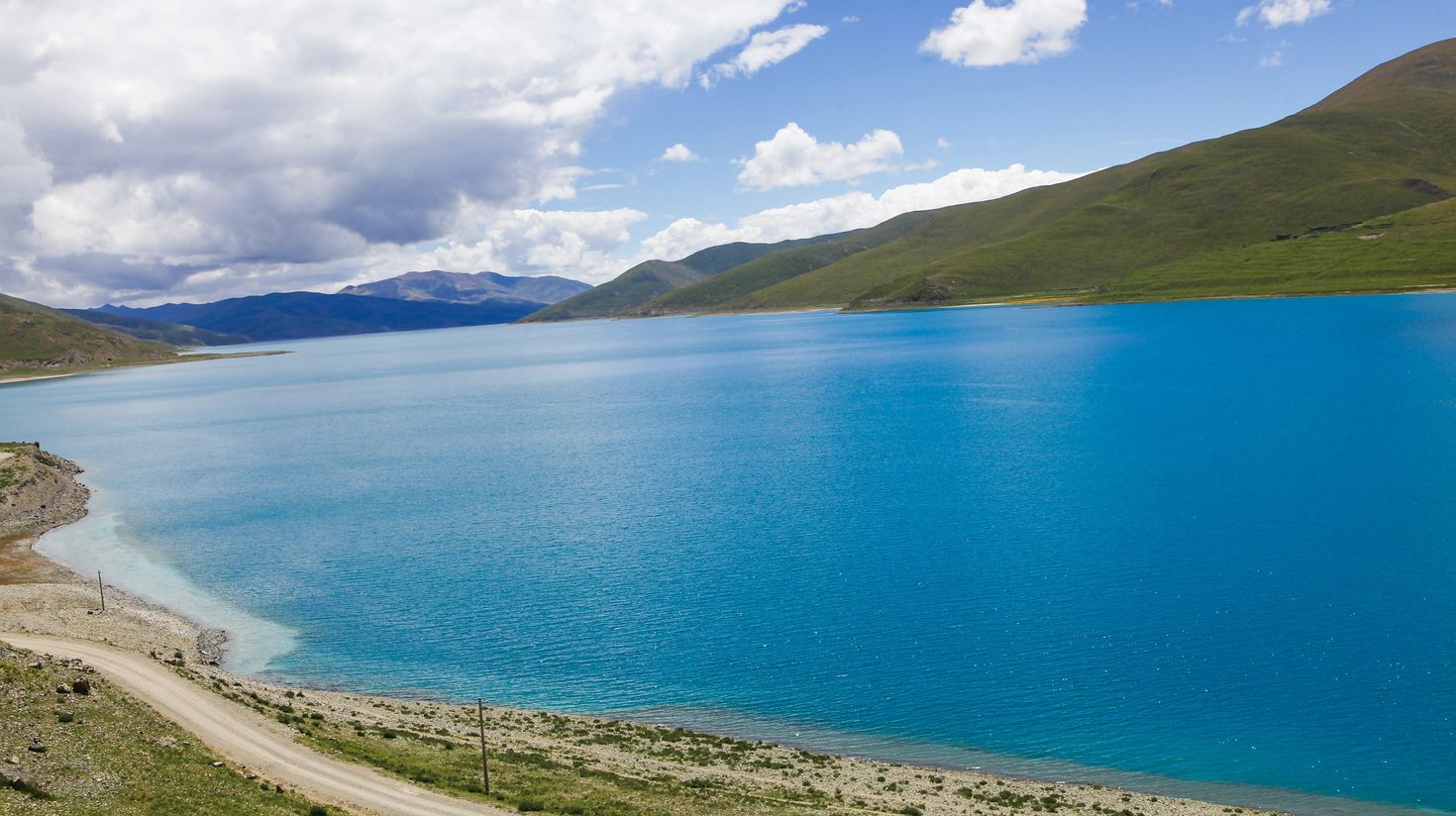 A scenerey of hills and Lake Yamdrok's clear blue water on Tibet visit