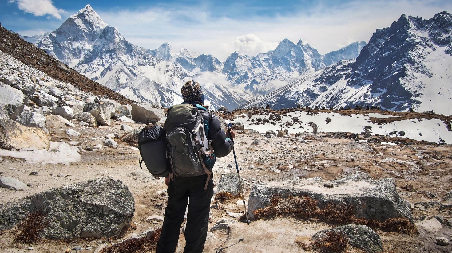 A hiker stopping to enjoy the view of the mountains while visiting Tibet