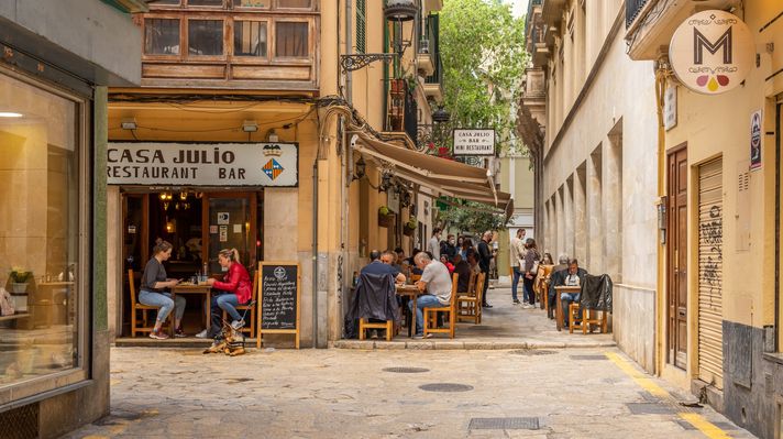 Restaurant terrace full of diners at noon in the historic center of Palma d