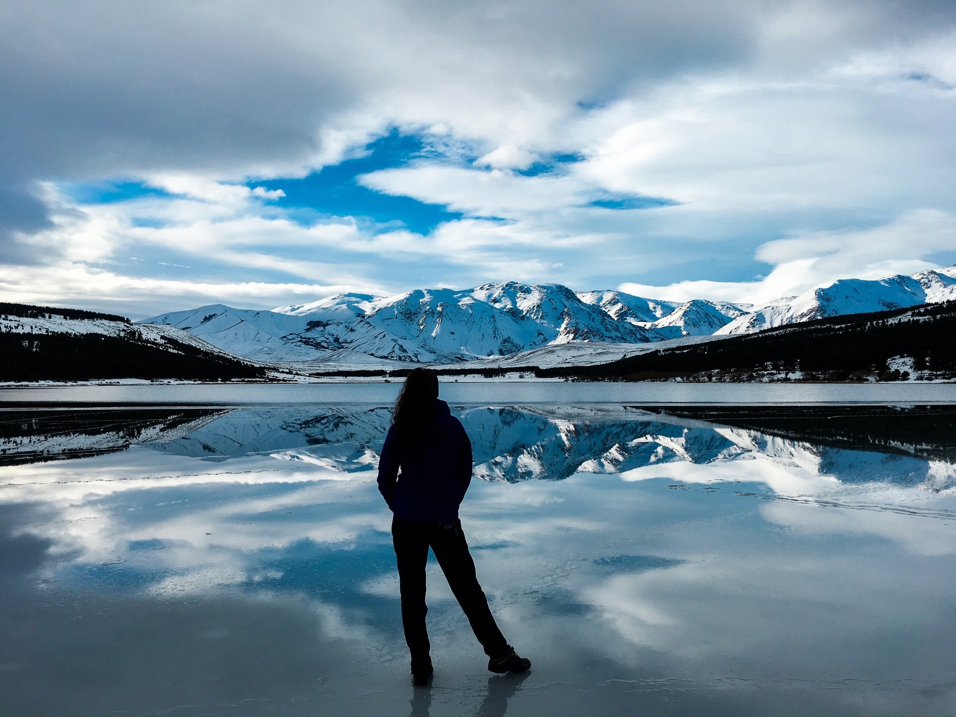 A tourist admires the stunning snowy-mountain scenery during winter in Argentina