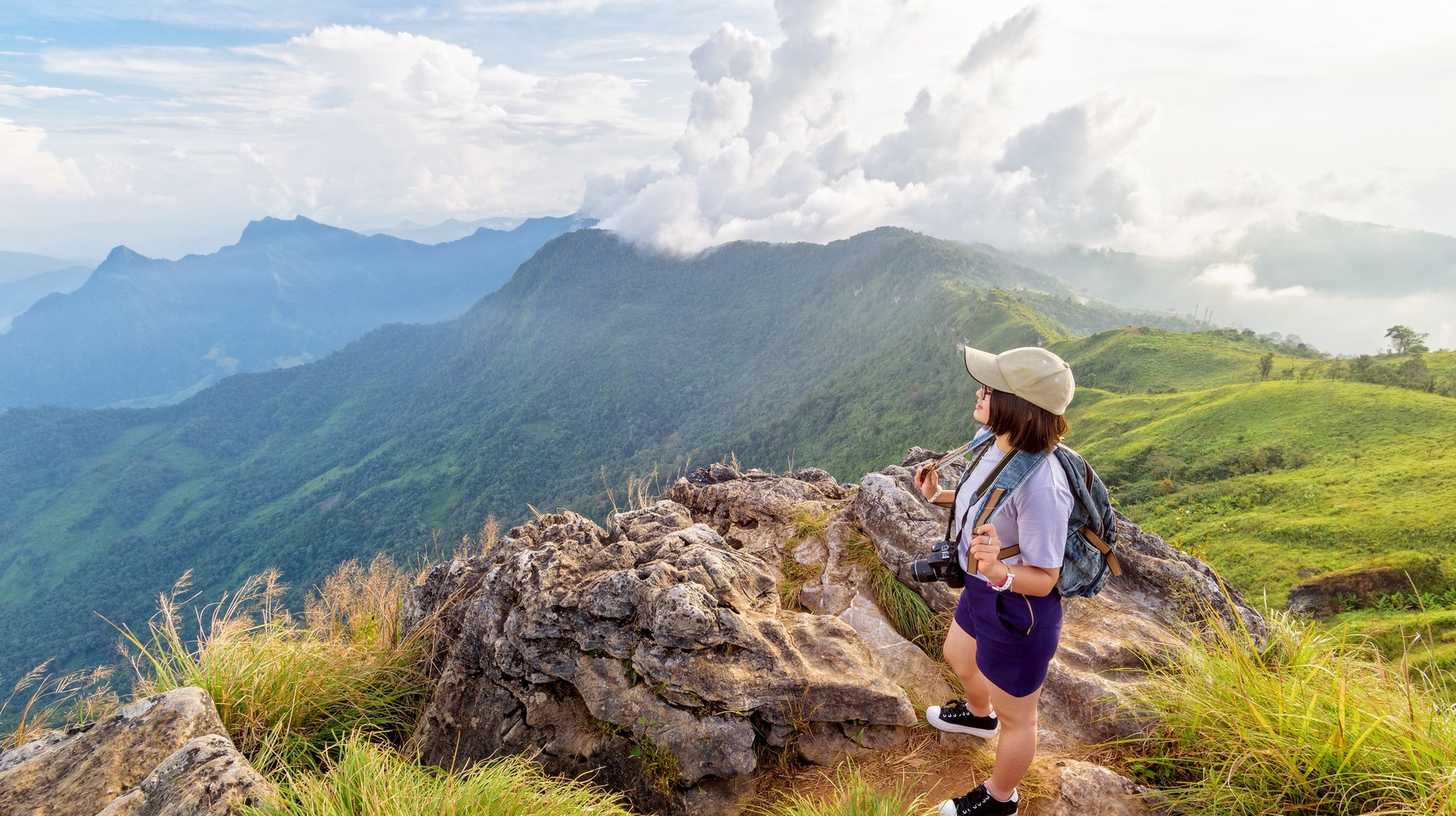 Hike through the stunning mountains and witness the breathtaking sunset during winter in Thailand. Hiker girl admiring beautiful landscape of nature of mountain range during winter in Thailand.