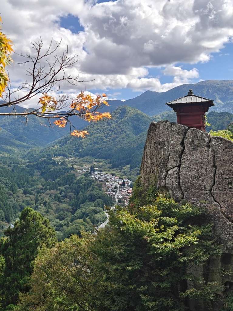 An ancient pagoda temple on top of a hill with a scenic valley below
