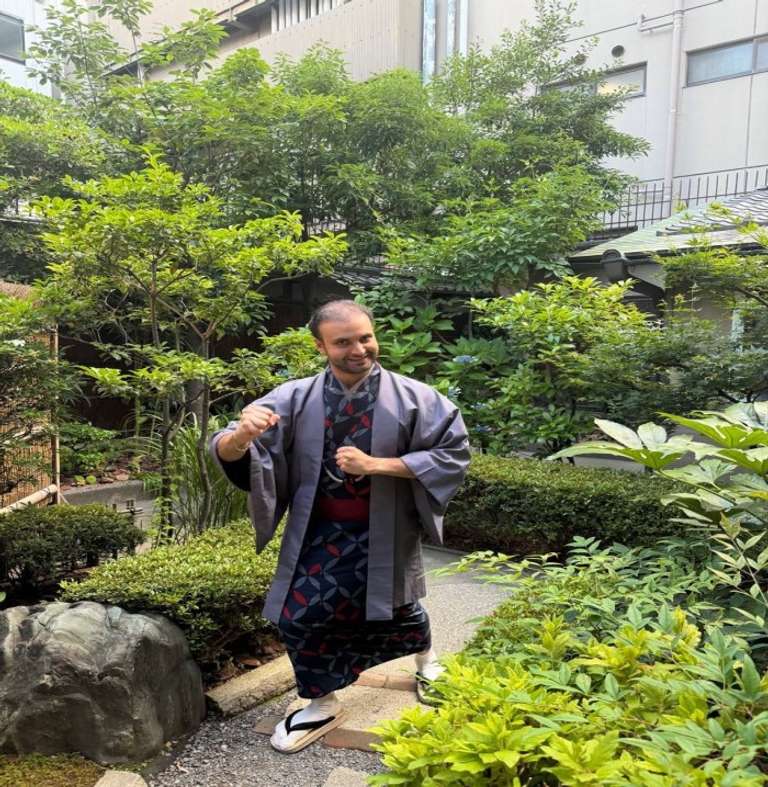 A man in traditional Japanese clothes in a garden