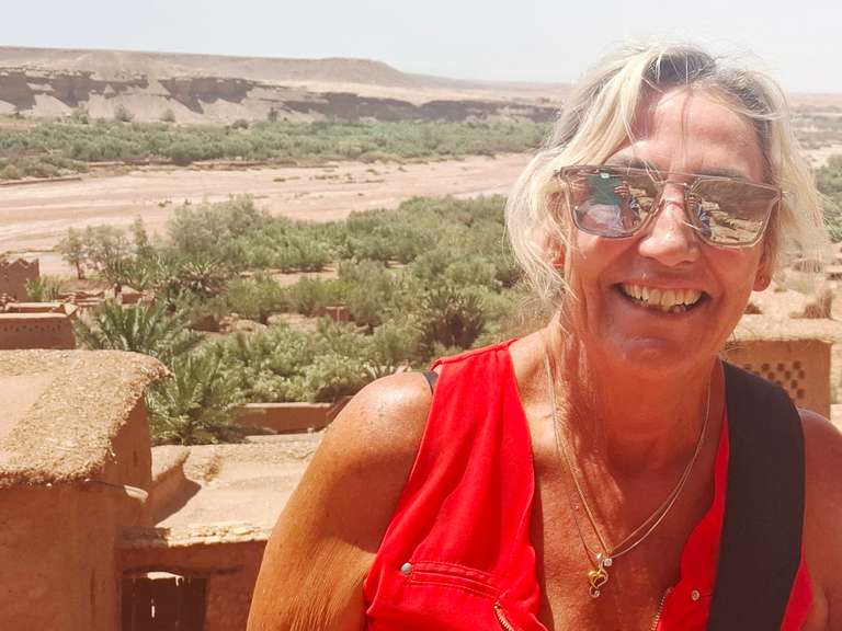 Picture of an elderly woman in red shirt against the desert background