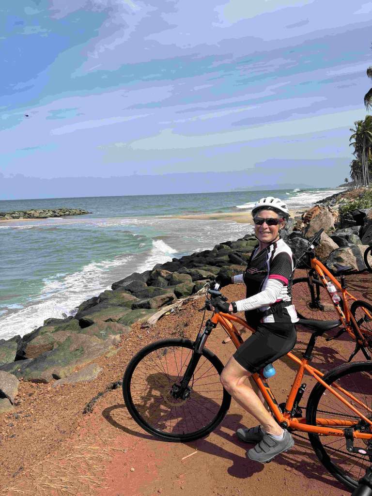 A woman in her 60s on a cycle next to the sea