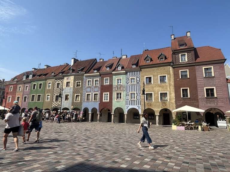 A row of colorful houses next to a stone-patched street in Poland